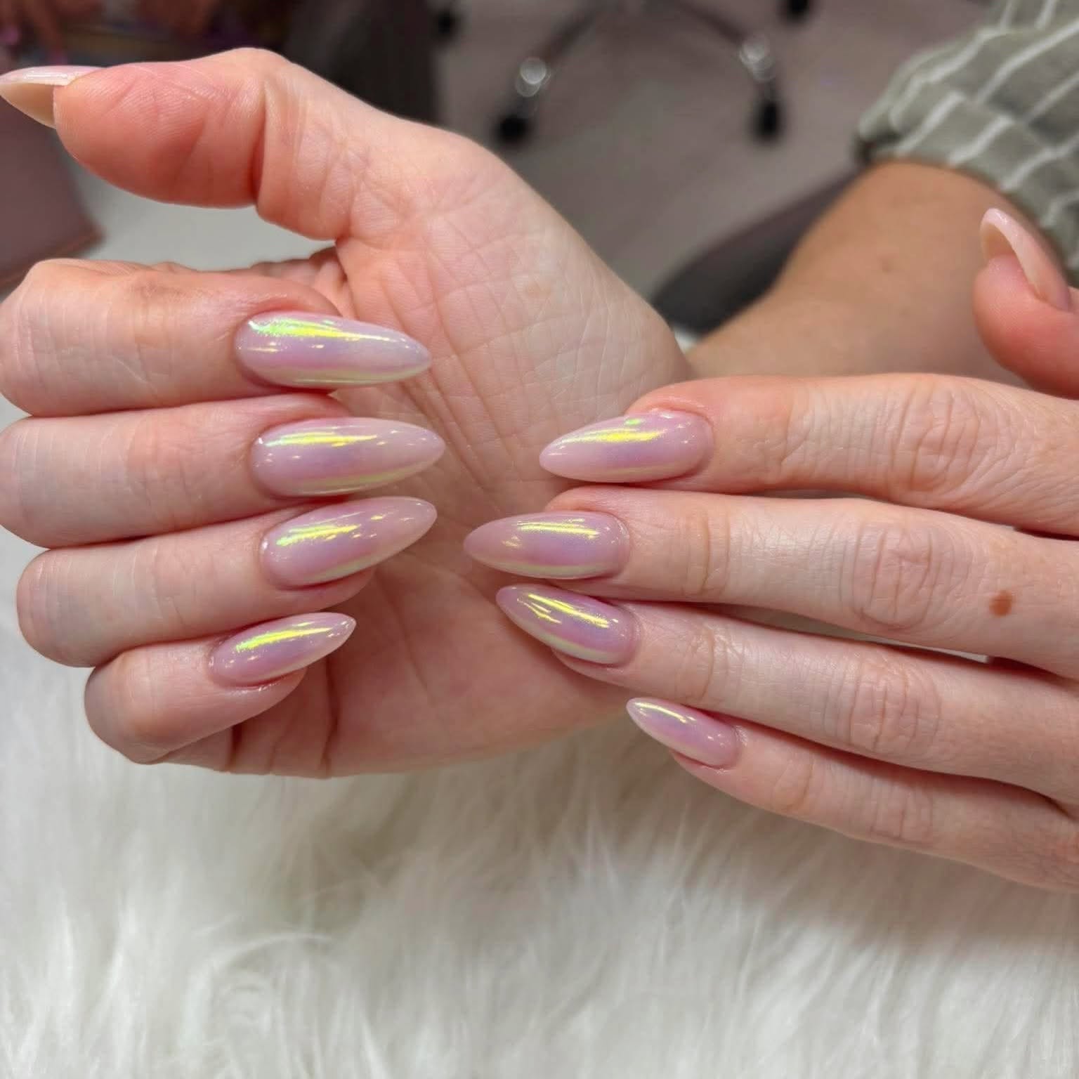 Almond-shaped bio gel nails in soft pink with an iridescent yellow-green shimmer
