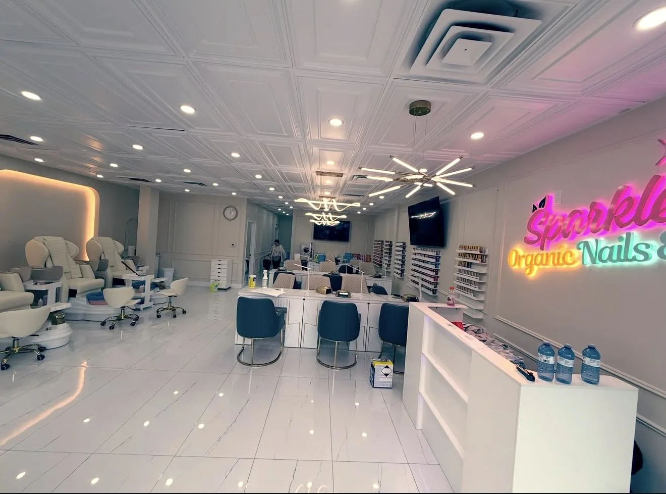 Reception desk, manicure tables and pedicure chairs inside sparkle organic nails & spa.
